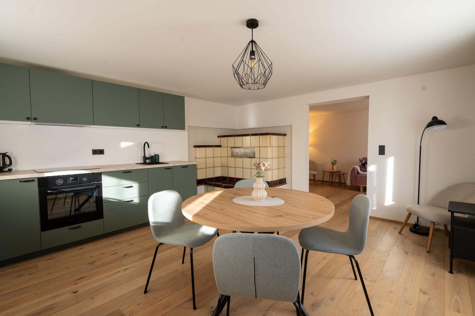Wohnzimmer der Ferienstube Dornbirn Kehlegg mit Esstisch, Küche und Kachelofen